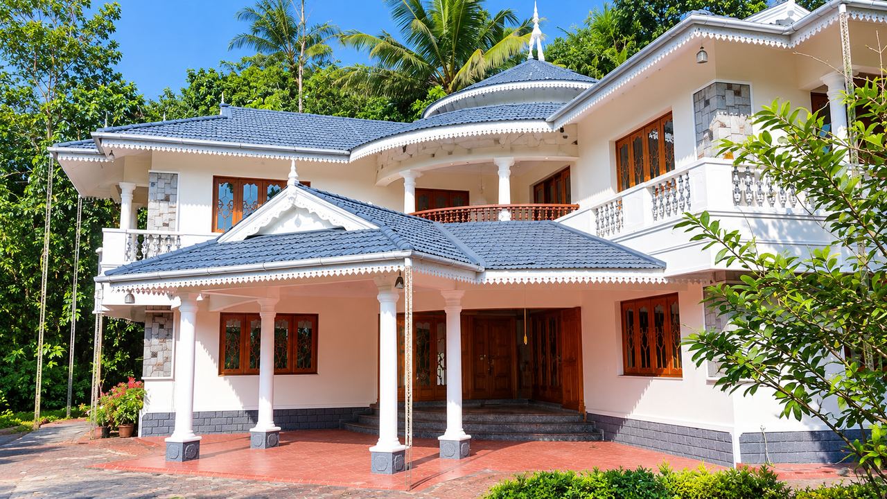Anugraha Homestay — a white two-storey bungalow with a blue-grey tiled roof, among trees in the hills